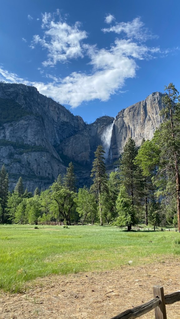 Yosemite Valley waterfall view with granite cliffs and green meadow in California