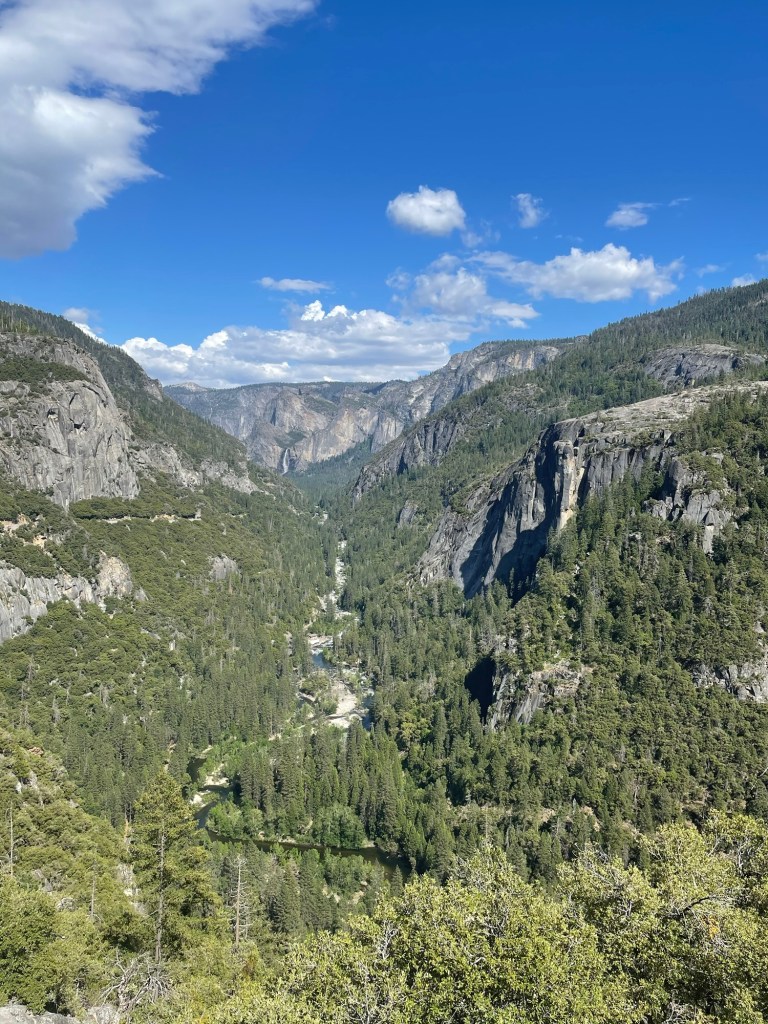 Wide view of Yosemite Valley with granite cliffs and open meadow landscape